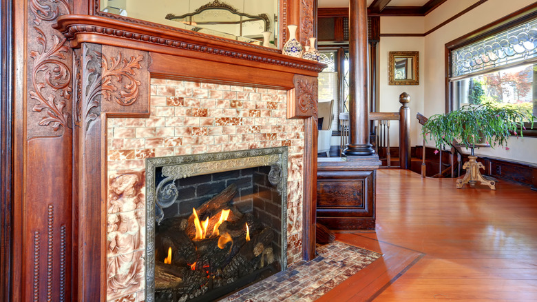 Antique fireplace in a home with handcrafted tile and hand carved wood detail