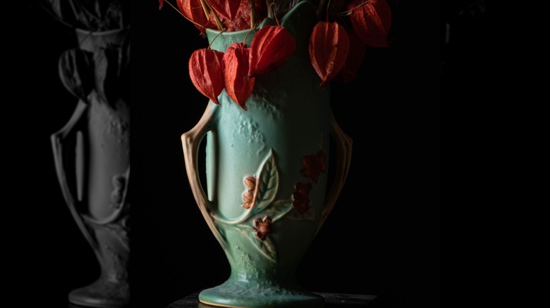A stylized shot of a Roseville pottery vase with Chinese lantern flowers.