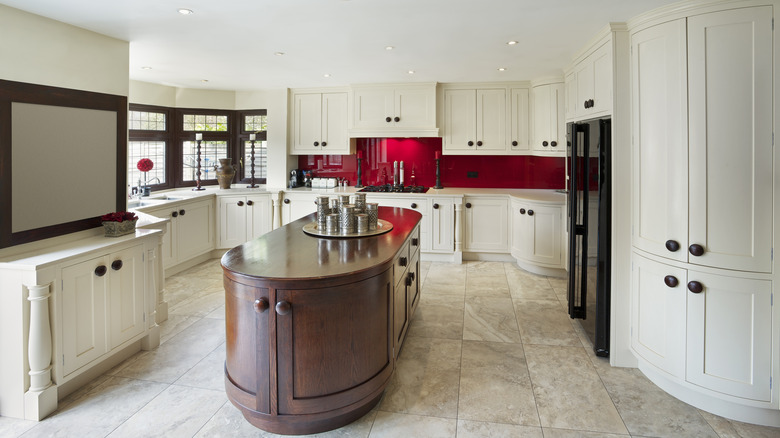 Kitchen with round wood island and red backsplash