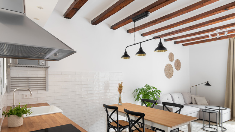 A modern kitchen with straight wooden ceiling beams.