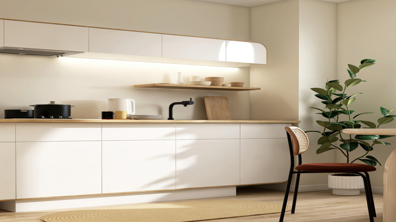 A modern kitchen with small upper cabinets that leave space between them and the ceiling.