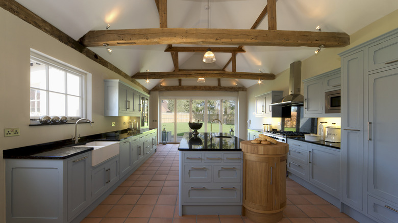 A kitchen with raw wood beams running across the ceiling.