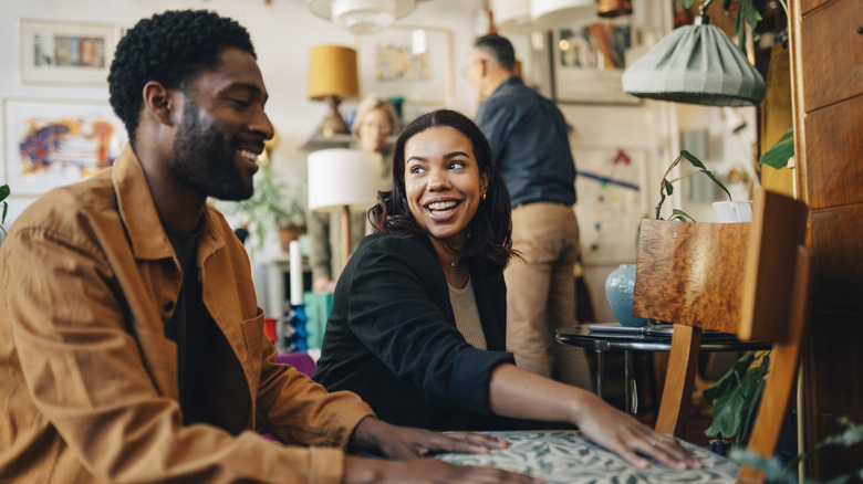 Two people looking at a chair in a thrift shop