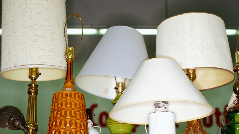 A variety of lamps with lampshades at a thrift store
