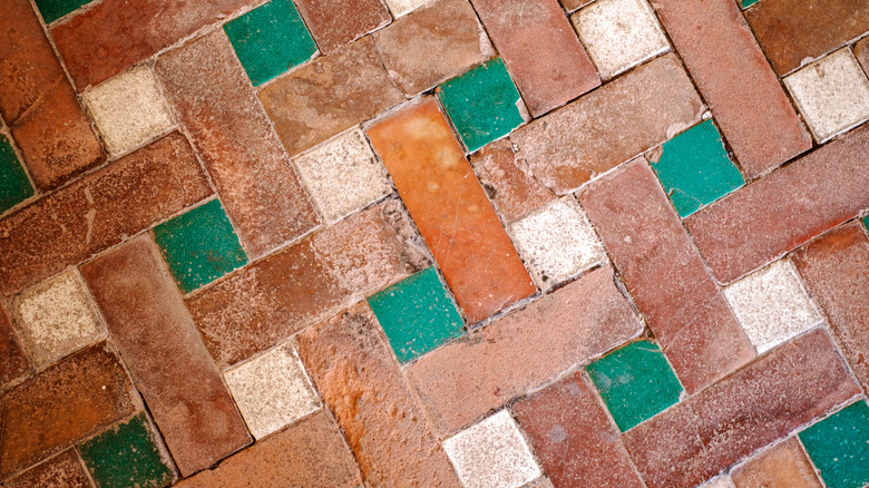 A terracotta floor with colorful painted tiles