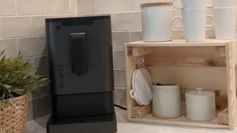 Crate on countertop with mugs and other coffee items stacked on it