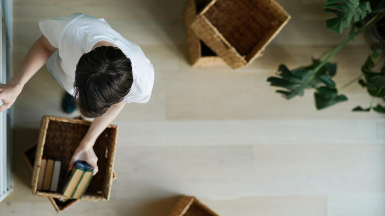 An overhead view of a person putting books in baskets