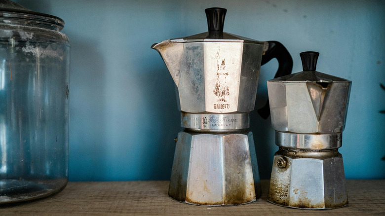 Two moka pots sitting on a shelf