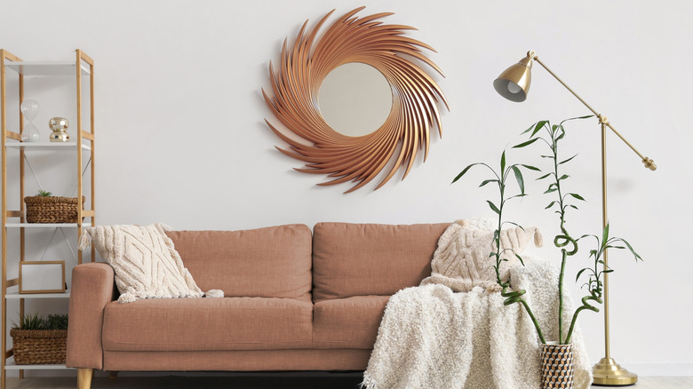 A tall floor lamp stands near a pink couch in a neat room