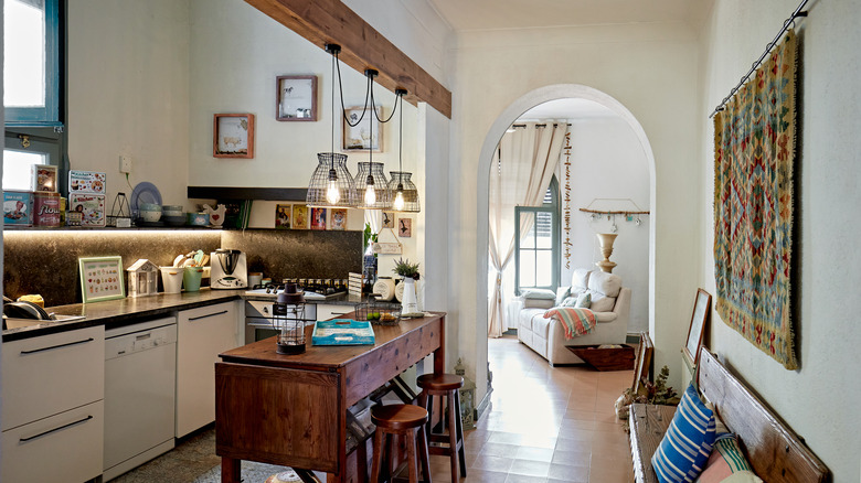 Modern rustic kitchen with wooden beam, high table, and barstool chairs