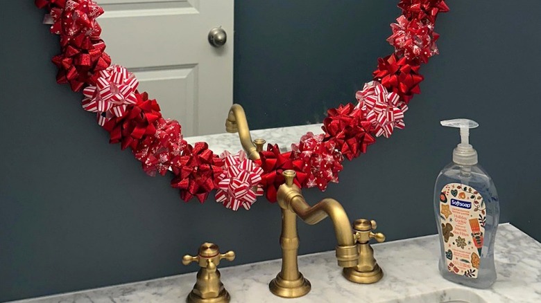 Gift bows around bathroom mirror frame as festive holiday decor