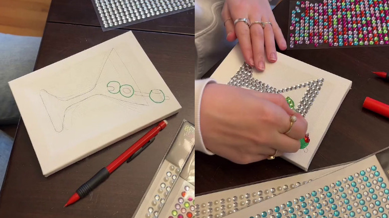 Person creating canvas art using craft gem stickers