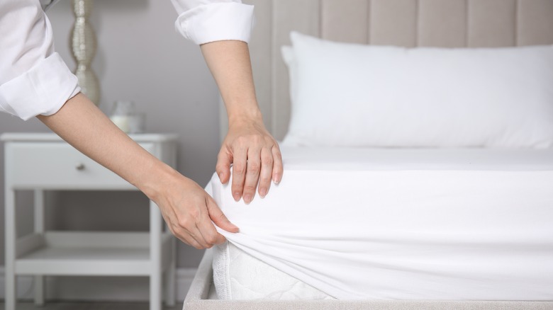 Person putting protector on mattress