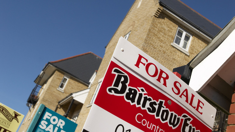 Townhouses with for sale signs out front