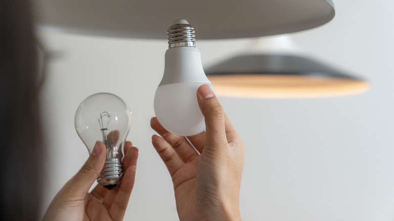 Person switching out an incandescent bulb for an LED one