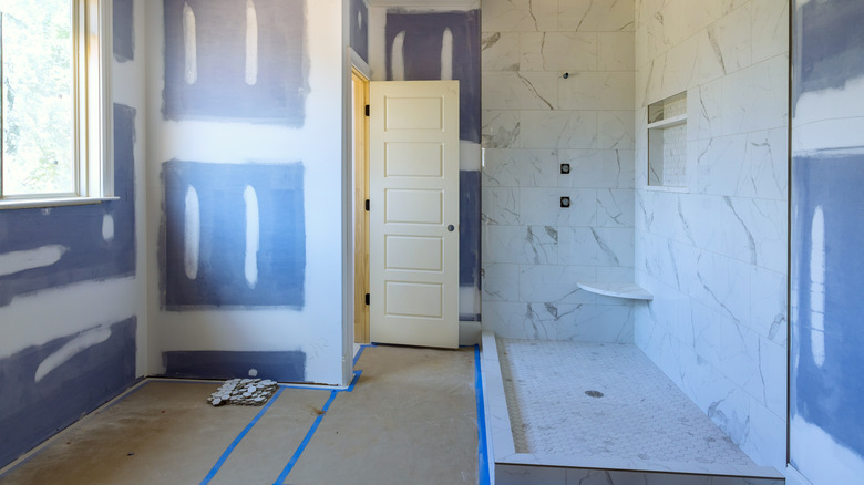 Bathroom being renovated with bare floors and walls