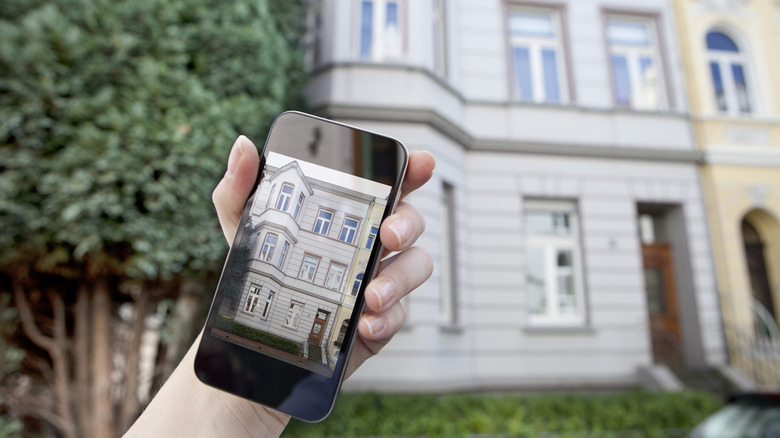 Image of phone screen showing photo of home in front of home.