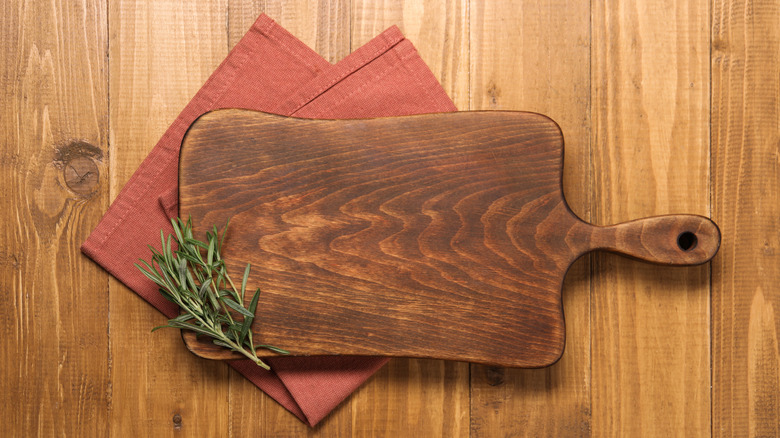 A cutting board on a couple of kitchen towels