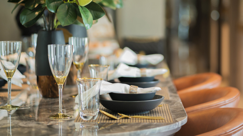 Simple table setting with plant center pieces and gold accented drink and dinner ware