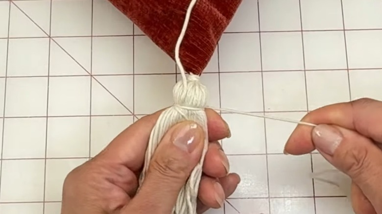 person DIYing a tassel on a pillow