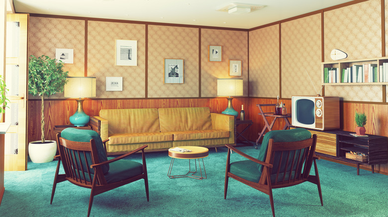 A vintage living room interior with bright blue carpet and mid-century furniture