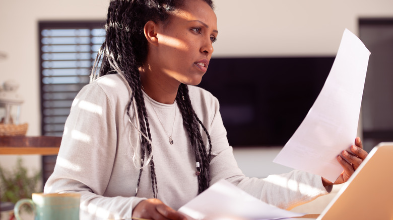 woman reading documents at desk