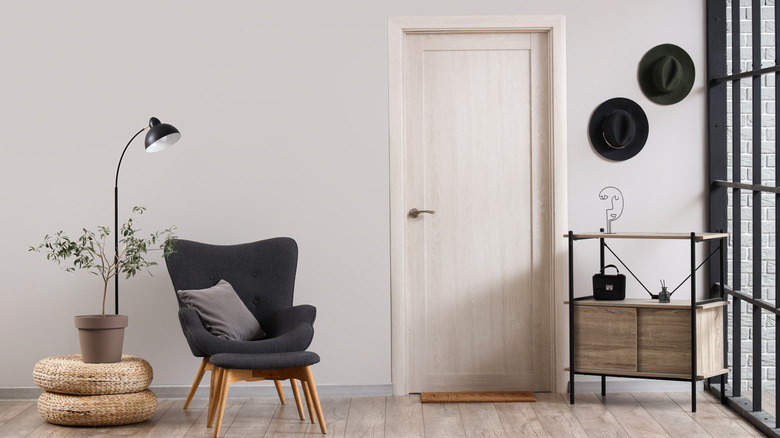 A modern sitting area with a plain grey door on the wall