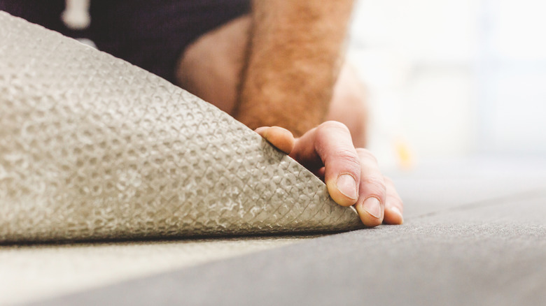 A worker installing neutral colored carpet