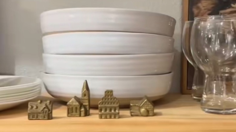 Brass vilage figurines on a shelf