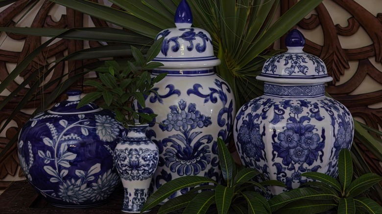 Collection of ginger jars on shelf with plant