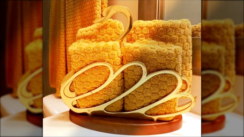 An '80s brass swan magazine holder contains hand towels.