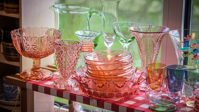 Vintage colored glass items on display at a thrift store