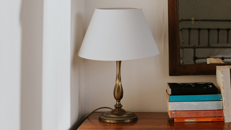 A lamp sitting on a table next to books