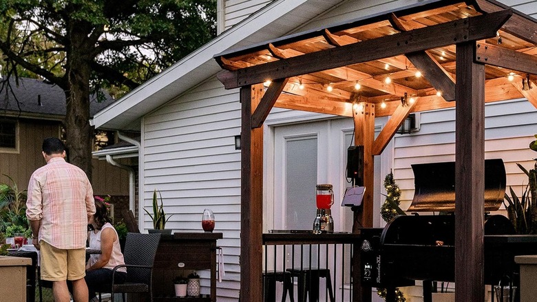 wooden pergola with grill seating