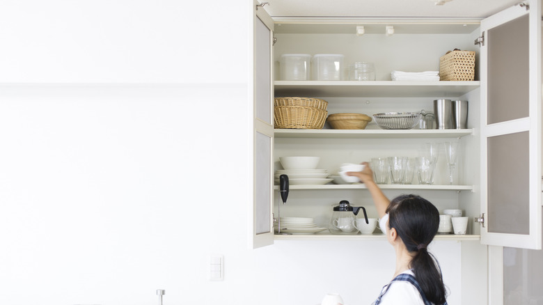 Woman organizing kitchen cabinets