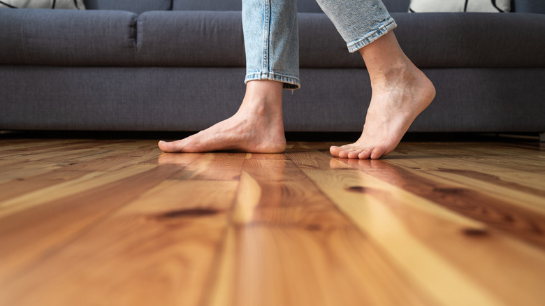 woman walking across wooden floor