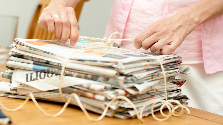 woman unties newspapers