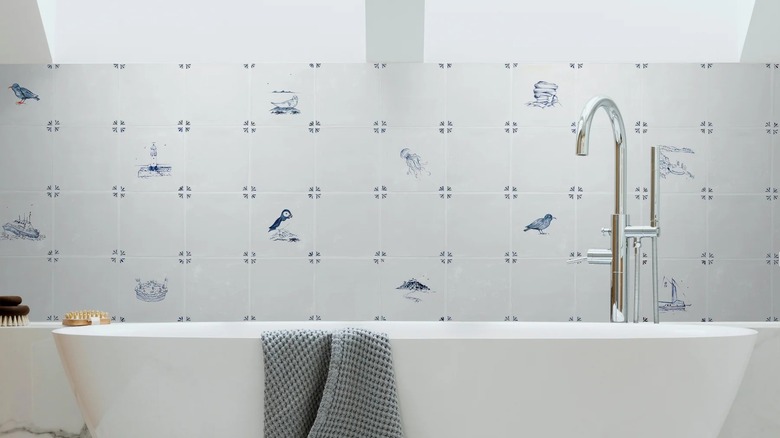 A white bathroom decked with intricate, blue hand-painted tiles on one wall