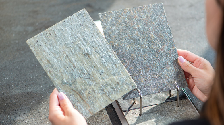 Person choosing between two samples of natural stone
