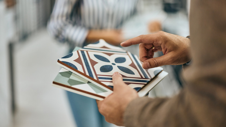 Someone holding onto tile samples