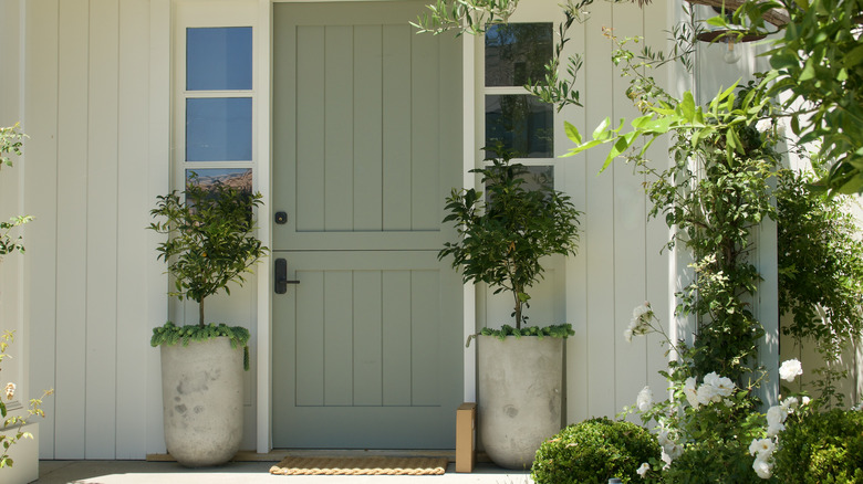 The facade of a home with a warm green front door