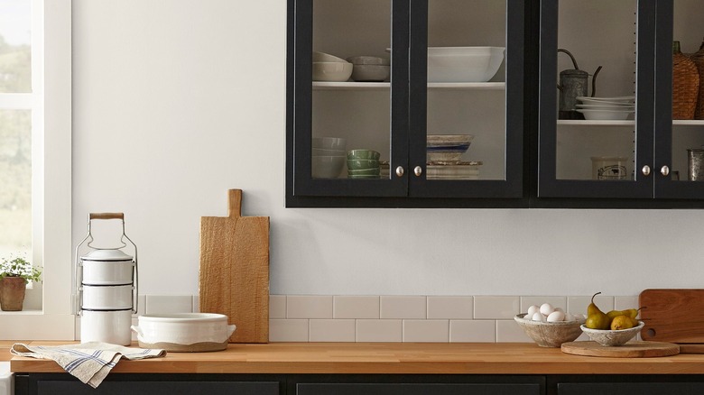 A staged kitchen with black cabinets and Silos White as the background color