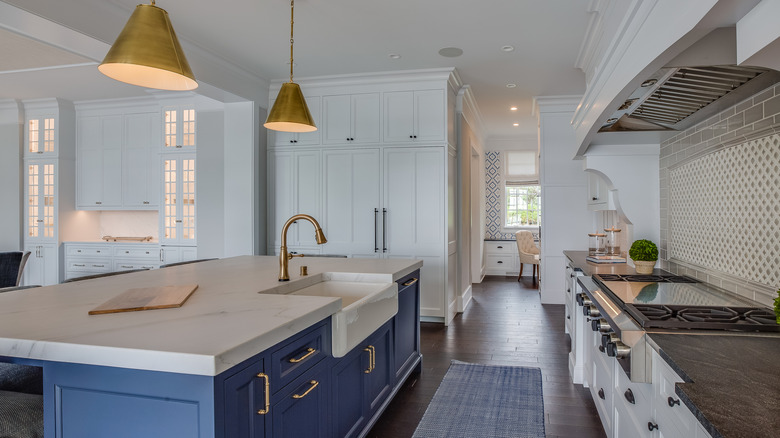 Kitchen with brass lighting, fixtures, and cabinet handles