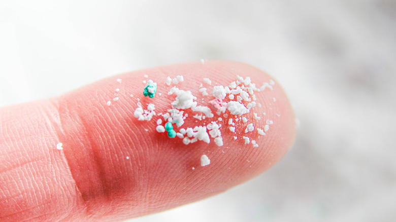 Microplastic on a finger, close up