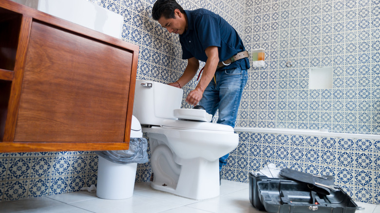 man installing toilet