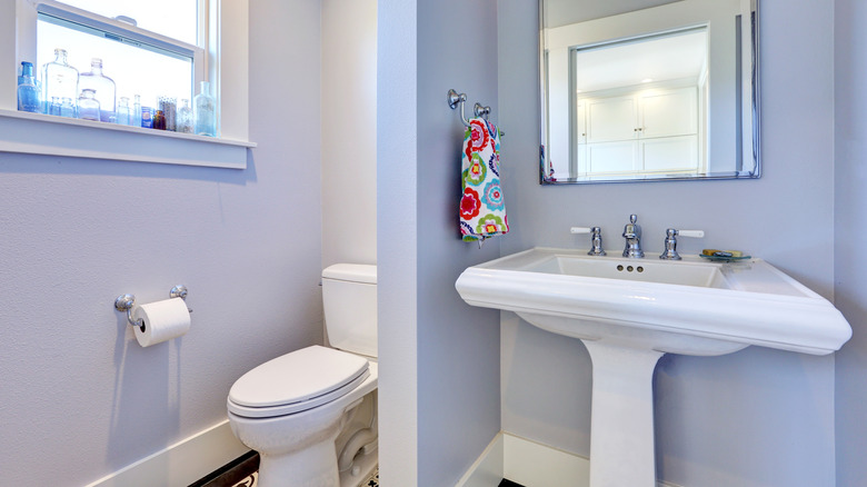 toilet in bathroom with half wall