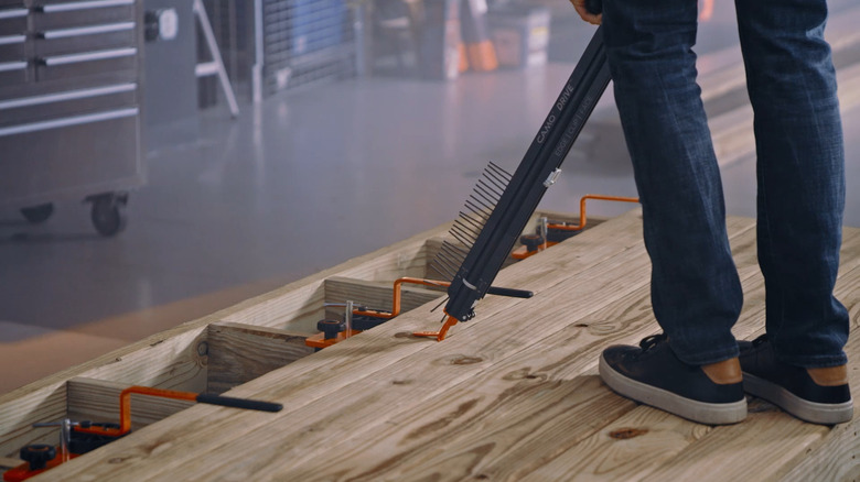 a man demonstrates how to use a CAMO DRIVE tool for fastening deck boards