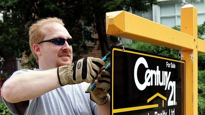 Man hangs Century 21 sign outside home for sale