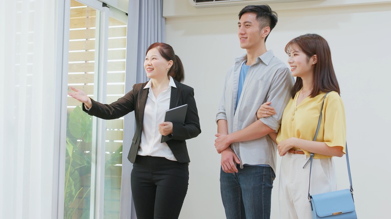 woman showing home to couple