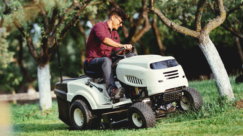 A man cutting grass with a ride-on lawn mower